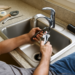 DIY step-by-step guide on how to install a kitchen sink faucet, featuring tools and a new faucet in the installation process