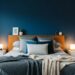 Modern bedroom featuring a navy blue accent wall, minimalist decor, wooden headboard, and soft neutral bedding for home decor inspiration.