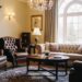 Traditional living room furniture featuring rich wood pieces, tufted sofa, leather armchairs, and vintage lighting creating a timeless and cozy space.