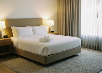 A cozy, modern bedroom with a queen bed and an 8x10 area rug extending beneath, showcasing ideal rug placement for queen beds.