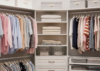 A pristine, well-organized walk-in closet with color-coded clothes, neatly folded sweaters, and storage boxes. The image showcases efficient space utilization and a clean, stress-free environment, illustrating how to organize a closet effectively.