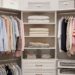 A pristine, well-organized walk-in closet with color-coded clothes, neatly folded sweaters, and storage boxes. The image showcases efficient space utilization and a clean, stress-free environment, illustrating how to organize a closet effectively.